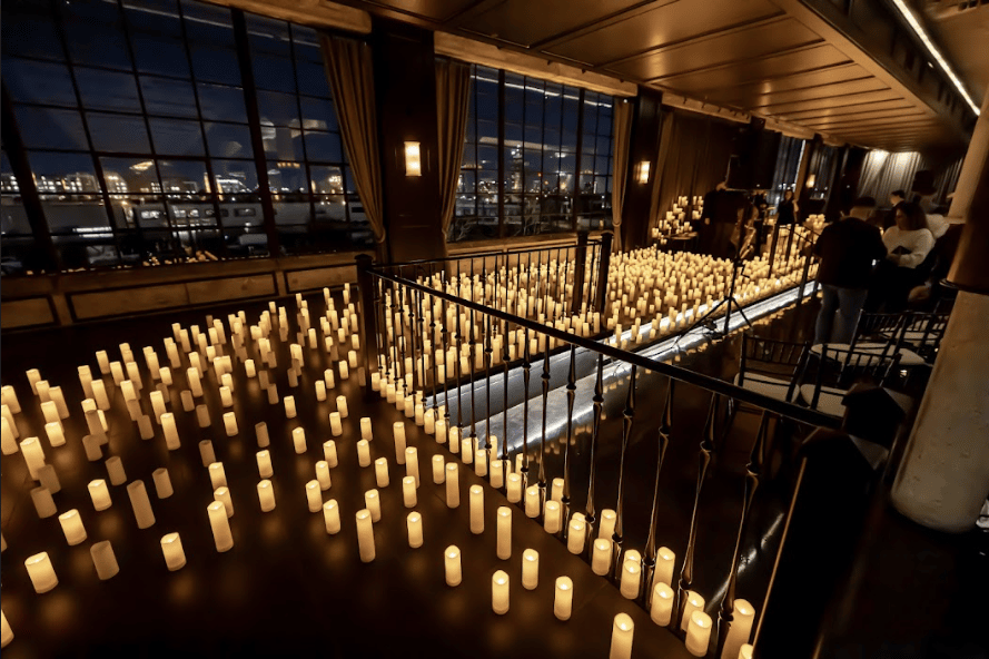 Upstairs in the Astorian and the floor is covered in candles with a big window in the background. 