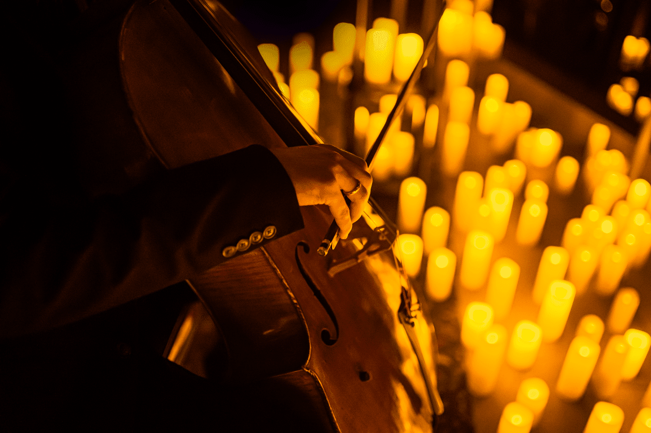 A musician playing the cello by candlelight.