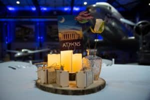 A table set up in a flight museum features a postcard for Athens