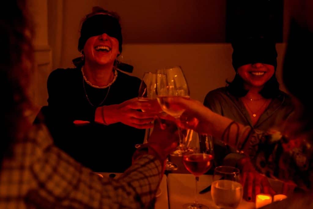 A few blindfolded friends cheerily toasting at Dining in the Dark