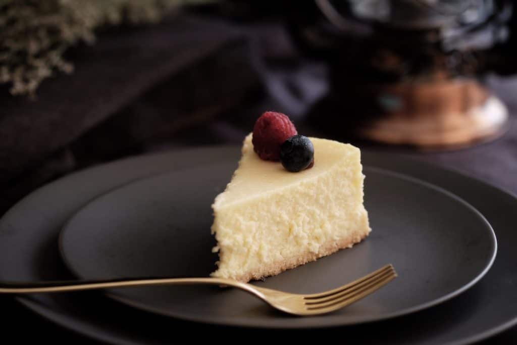 A slice of New York cheesecake topped with berries.